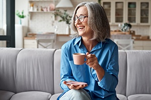 Mature woman smiling while drinking cup of coffee